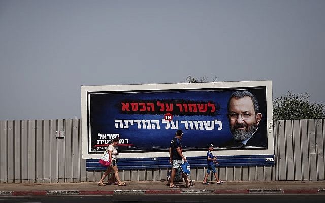 People walk next to election poster for Ehud Barak, head of the Israel Democratic Party, in Tel Aviv, July 17, 2019. (Miriam Alster/Flash90) People walk next to election poster for Ehud Barak, head of the Israel Democratic Party, in Tel Aviv, July 17, 2019. (Miriam Alster/Flash90)