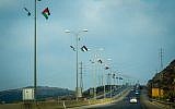 Right-wing activists hang Palestinian flags along a West Bank highway on July 7, 2019 (Courtesy of Regavim)