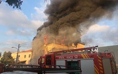 Firefighters work to extinguish a blaze at the home of Carmel Mauda in the central city of Rosh Ha'ayin on July 6, 2019. (Israel Police)