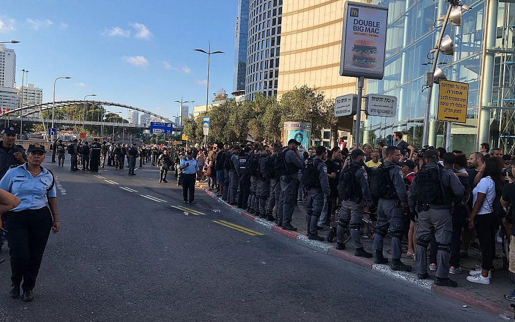 Police officers form a line to prevent protesters from rushing into the street at Hashalom interchange in central Tel Aviv amid a protest by the Ethiopian-Israeli community, July 3, 2019. (Naomi Lanzkron)