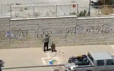 Authorities clean up graffiti in Beit Shemesh appearing to say "Aliza Bloch is Hitler" on July 5, 2019. (Screen capture: Twitter)