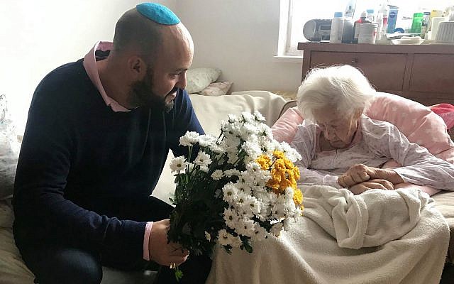Krystyna Danko receiving flowers from Jonny Daniels on in her apartment in Warsaw, Poland on her 102nd birthday on July 9, 2019. (From the Depths via JTA) Krystyna Danko receiving flowers from Jonny Daniels on in her apartment in Warsaw, Poland on her 102nd birthday on July 9, 2019. (From the Depths via JTA)