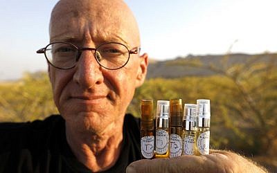 Farmer Guy Erlich shows ampules of scented oils extracted from plants and trees at a farm on a small hill near the settlement of Almog in the West Bank, on May 28, 2019 (MENAHEM KAHANA / AFP)