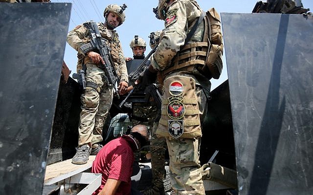 Iraq's rapid response forces detain a man as they storm a house in the Tarmiyah district, north of Baghdad, searching for wanted Islamic State group suspects on July 21, 2019. (AHMAD AL-RUBAYE / AFP) Iraq's rapid response forces detain a man as they storm a house in the Tarmiyah district, north of Baghdad, searching for wanted Islamic State group suspects on July 21, 2019. (AHMAD AL-RUBAYE / AFP)