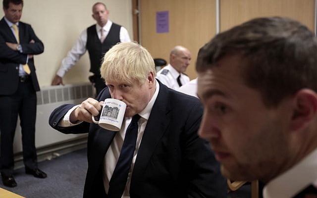 Britain's Prime Minister Boris Johnson (C) drinks from a HMP Leeds mug as he talks with prison staff during a visit to HM Prison Leeds, a Category B men's prison in Leeds, northern England, on August 13, 2019. (Jon Super / POOL / AFP) Britain's Prime Minister Boris Johnson (C) drinks from a HMP Leeds mug as he talks with prison staff during a visit to HM Prison Leeds, a Category B men's prison in Leeds, northern England, on August 13, 2019. (Jon Super / POOL / AFP)