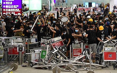 Pro-democracy protestors block the entrance to the airport terminals after a scuffle with police at Hong Kong's international airport late on August 13, 2019. (Manan VATSYAYANA / AFP)