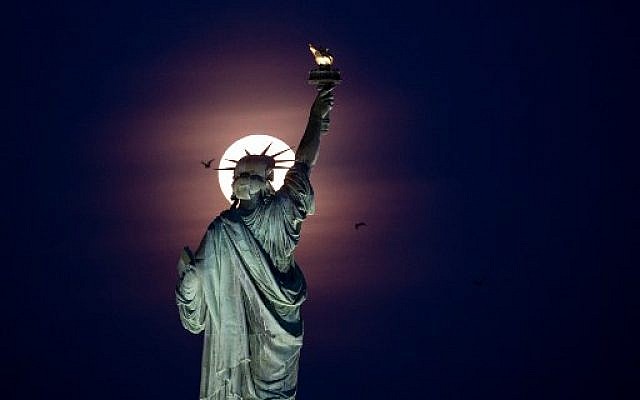 A full moon rises behind the Statue of Liberty in New York City, on May 18, 2019. (Photo by Johannes EISELE / AFP) A full moon rises behind the Statue of Liberty in New York City, on May 18, 2019. (Photo by Johannes EISELE / AFP)