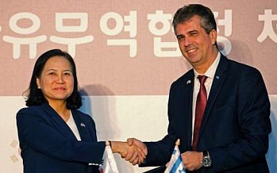 South Korean Trade Minister Yoo Myung-hee (L) and Israeli Economy and Industry Minister Eli Cohen stand after signing a free-trade agreement between Israel and the Republic of Korea in Jerusalem on August 21, 2019.  (Photo by Gil COHEN-MAGEN / AFP)