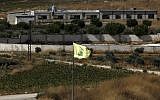 A Hezbollah flag in the Lebanon village of Aitaroun, near the northern Israeli moshav of Avivim, on August 26, 2019. (Jalaa Marey/AFP)