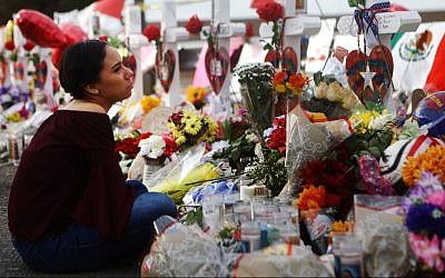 Yamileth Lopez with a photo of her deceased friend Javier Amir Rodriguez at a makeshift memorial for victims of a mass shooting which left at least 22 people dead, on August 6, 2019 in El Paso, Texas. Mario Tama/Getty Images/AFP