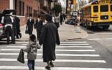 Pedestrians walk past a yeshiva in the South Williamsburg neighborhood of Brooklyn, April 9, 2019. (Drew Angerer/Getty Images via JTA)