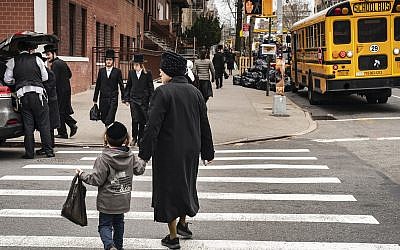 Pedestrians walk past a yeshiva in the South Williamsburg neighborhood of Brooklyn, April 9, 2019. (Drew Angerer/Getty Images via JTA)