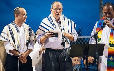 From left to right, Rabbis Ben Zeidman and Scott Rosenberg speak at an interfaith vigil with Msgr. Arturo Banuelas following the mass shooting in El Paso, Texas, Aug. 4, 2019. (Jordyn Rozensky/ Frontera Studio via JTA)