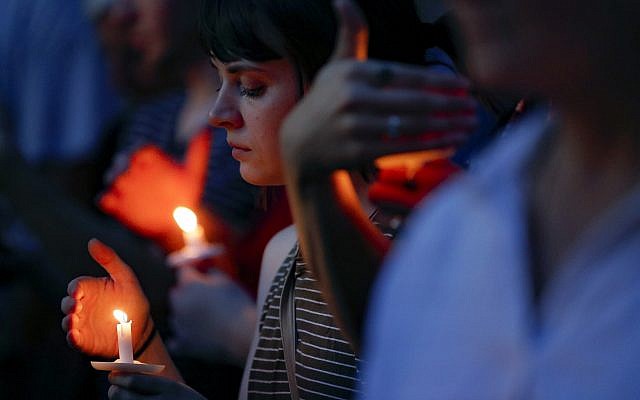 Mourners bow their heads in prayer as they gather for a vigil at the scene of a mass shooting on Sunday, August 4, 2019, in Dayton, Ohio. (AP Photo/John Minchillo) Mourners bow their heads in prayer as they gather for a vigil at the scene of a mass shooting on Sunday, August 4, 2019, in Dayton, Ohio. (AP Photo/John Minchillo)