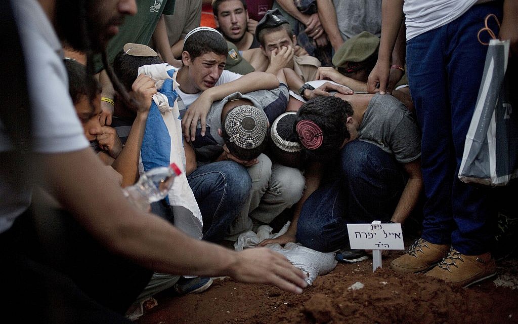 In this July 1, 2014 file photo, family and friends of three Israeli teenagers who were abducted and killed mourn over the grave of Eyal Yifrah, during their funeral in Modi'in. (AP Photo/Ariel Schalit, File) In this July 1, 2014 file photo, family and friends of three Israeli teenagers who were abducted and killed mourn over the grave of Eyal Yifrah, during their funeral in Modi'in. (AP Photo/Ariel Schalit, File)