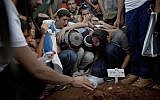 In this July 1, 2014 file photo, family and friends of three Israeli teenagers who were abducted and killed mourn over the grave of Eyal Yifrah, during their funeral in Modi'in. (AP Photo/Ariel Schalit, File)