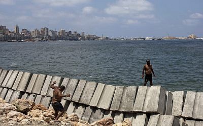 Workers prepare to place cement blocks to reinforce the sea wall against rising water levels on the corniche in Alexandria, Egypt, August 8, 2019. (Maya Alleruzzo/AP)