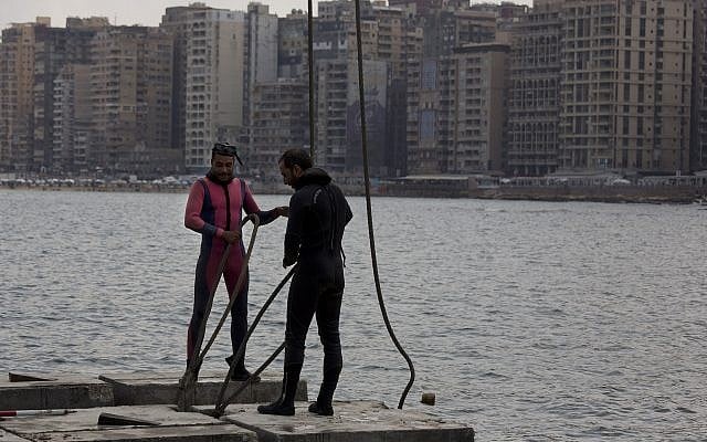 Workers prepare to place cement blocks to stave off rising water levels near the corniche in Alexandria, Egypt,  August 8, 2019. (Maya Alleruzzo/AP)