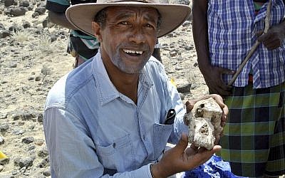 Yohannes Haile-Selassie, holds a fossilized cranium of Australopithecus anamensis. (Undated, Cleveland Museum of Natural History via AP)