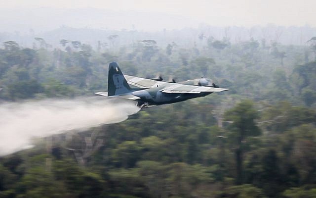 In this photo released by Brazil Ministry of Defense, a C-130 Hercules aircraft dumps water to fight fires burning in the Amazon rainforest, in Brazil on August 24, 2019. (Brazil Ministry of Defense via AP) In this photo released by Brazil Ministry of Defense, a C-130 Hercules aircraft dumps water to fight fires burning in the Amazon rainforest, in Brazil on August 24, 2019. (Brazil Ministry of Defense via AP)
