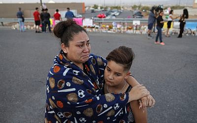 In this August 5, 2019, file photo, Clarissa Hernandez holds Ezra Magallanes as they speak with the media at a makeshift memorial for victims of a mass shooting at a shopping complex in El Paso, Texas. (AP Photo/John Locher, File)