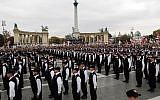 Some of the 600 members of the Jobbik created extreme-right wing "Magyar Garda" or Hungarian guard stand during their swearing-in ceremony in Budapest, Hungary, on Oct. 21, 2007,  wearing black uniforms bearing a variation on the red-and-white Arpad Stripes associated with Hungary's Nazi-aligned Arrow Cross party of WWII (AP Photo/Bela Szandelszky
