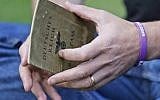 Illustrative photo of a man holding a Nazi-era German passport that belonged to his grandparent, October 5, 2016. (Frank Augstein/AP)