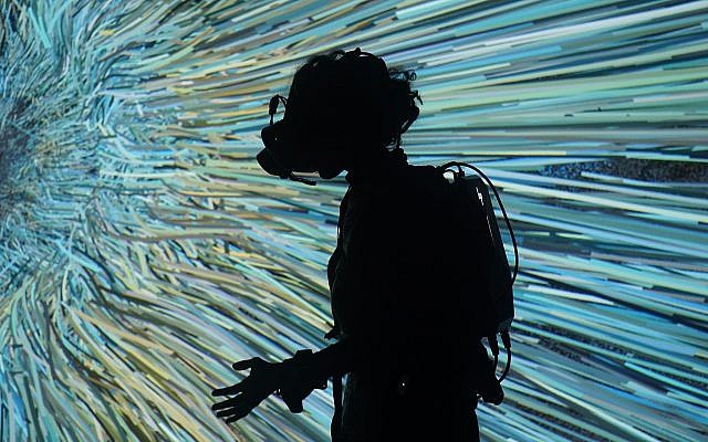 Illustrative: A visitor interacts with a display through a virtual reality goggles at the Saatchi Gallery in London, on Sunday, December 23, 2018. (AP Photo/Raphael Satter) Illustrative: A visitor interacts with a display through a virtual reality goggles at the Saatchi Gallery in London, on Sunday, December 23, 2018. (AP Photo/Raphael Satter)