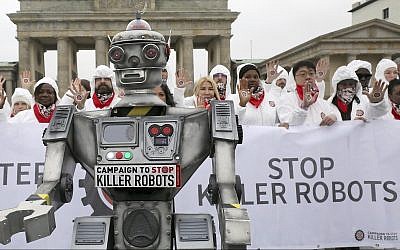 People take part in a 'Stop killer robots' campaign at Brandenburg gate in Berlin, Germany, Thursday, March 21, 2019. (Wolfgang Kumm/dpa via AP)