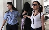 Police officers escort a 19-year-old British woman, center, from the Famagusta court in town of Paralimni, Cyprus, July 29, 2019. (AP/Petros Karadjias)