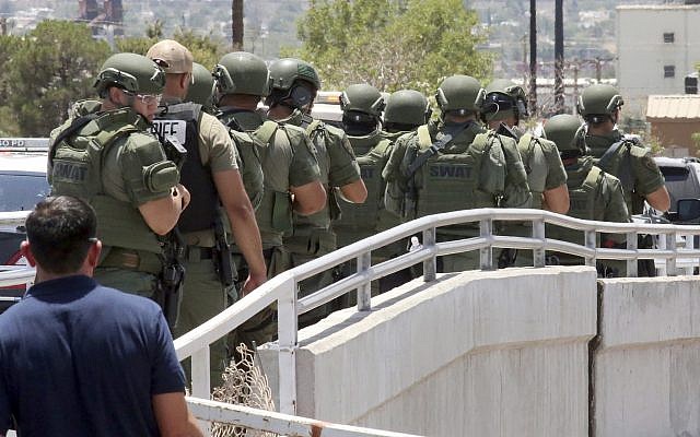 Law enforcement officers make their way along a walkway to the scene of a shooting at a shopping mall in El Paso, Texas, on Aug. 3, 2019 (AP Photo/Rudy Gutierrez)