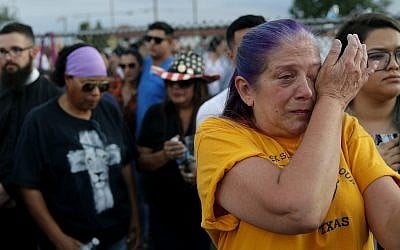 Cathe Hill wipes tears from her eyes during a vigil for victims of Saturday's mass shooting at a shopping complex, August 4, 2019, in El Paso, Texas. (AP Photo/John Locher)
