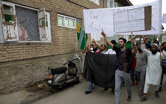 A Kashmiri Muslim woman, left, watches from her house as men hold placards and shout pro-freedom slogans during a demonstration after Friday prayers amid curfew like restrictions in Srinagar, India, Friday, Aug. 16, 2019. (AP Photo/Dar Yasin) A Kashmiri Muslim woman, left, watches from her house as men hold placards and shout pro-freedom slogans during a demonstration after Friday prayers amid curfew like restrictions in Srinagar, India, Friday, Aug. 16, 2019. (AP Photo/Dar Yasin)