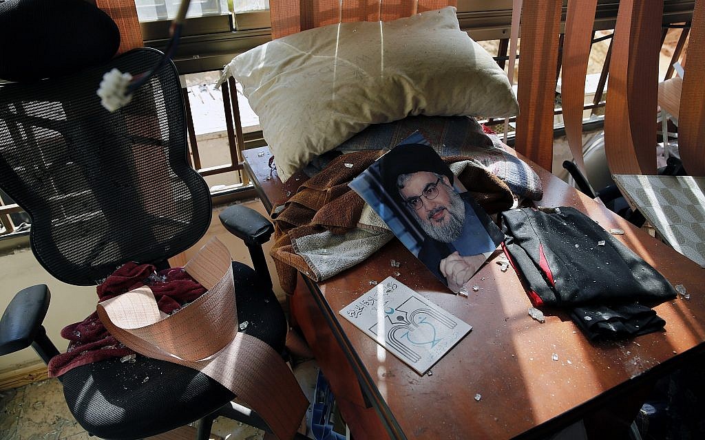 A poster of Hezbollah leader Sayyed Hassan Nasrallah is seen amid other damage inside the media office in a stronghold of the Lebanese Hezbollah group in a southern suburb of Beirut, Lebanon, Sunday, Aug. 25, 2019. (AP/Bilal Hussein)