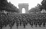 US soldiers of Pennsylvania's 28th Infantry Division march along the Champs Elysees, the Arc de Triomphe in the background, on Aug. 29, 1944, four days after the liberation of Paris, France (AP Photo/Peter J. Carroll)