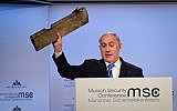 Prime Minister Benjamin Netanyahu shows a part of an Iranian drone as he speaks at the Munich Security Conference in Munich, Germany, on February 18, 2018. (Amos Ben Gershom/GPO)