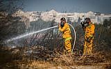 Firefighters extinguish the remains of a fire in at a forest in the city of Beit Shemesh, August 26, 2019. (Flash90)