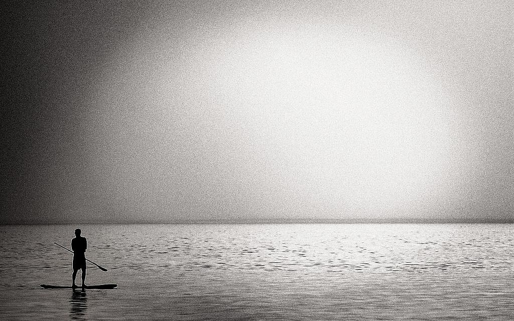 The Mediterranean sunset and a person on a standup paddle board (Courtesy Tal Paz-Fridman)