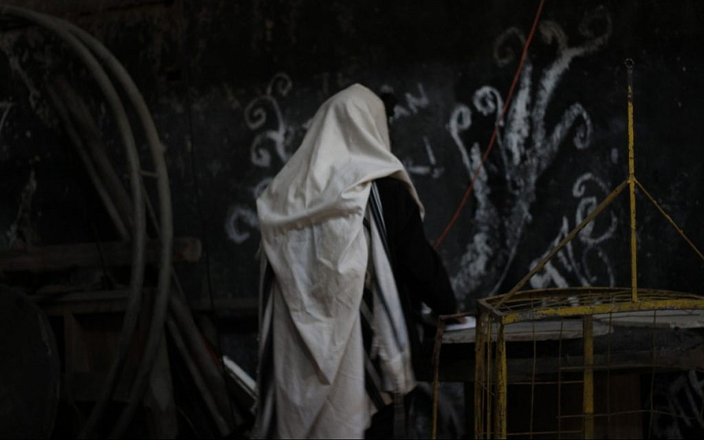 Rabbi Shneur Mizrahi of Buenos Aires prays in the newly-reclaimed synagogue in the Argentine capital's La Boca neighborhood. (Daniel Silicaro)