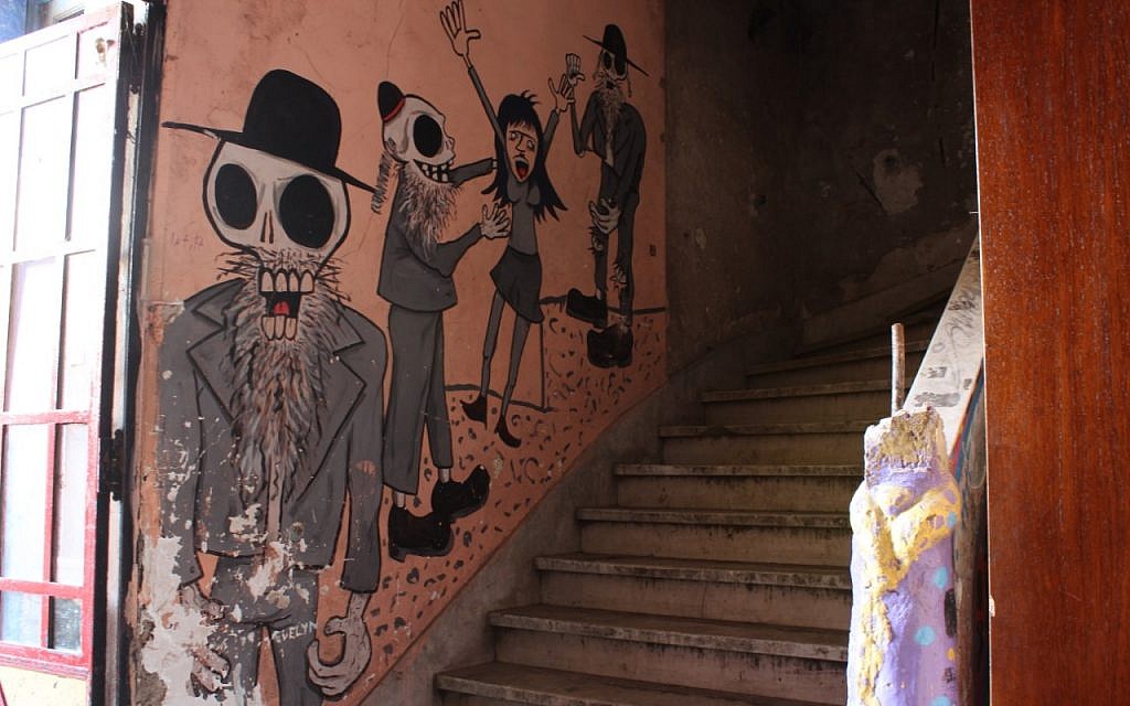 Anti-Semitic caricatures of dead Jews assaulting a woman are drawn onto the walls of the newly-reclaimed synagogue in Buenos Aires that for years had housed raves thrown by squatters. (Daniel Silicaro)