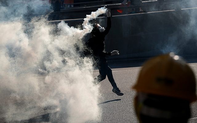 A protester throws a tear gas canister fired by riot police as they face off near the Legislative Council building and the Central Government building in Hong Kong, Monday, August 5, 2019. (AP Photo/Vincent Thian) A protester throws a tear gas canister fired by riot police as they face off near the Legislative Council building and the Central Government building in Hong Kong, Monday, August 5, 2019. (AP Photo/Vincent Thian)