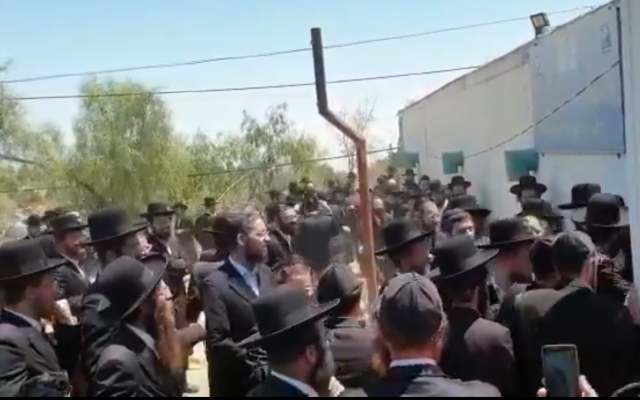 Haredi demonstrators clash with police outside of a warehouse in the southern town of Arad on August 11, 2019. (Screen capture/Twitter) Haredi demonstrators clash with police outside of a warehouse in the southern town of Arad on August 11, 2019. (Screen capture/Twitter)