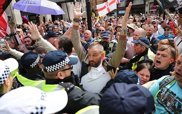 Supporters of far-right activist Stephen Yaxley-Lennon, known as Tommy Robinson, are restrained by police, in Oxford Street, London, Aug. 3, 2019. (Steve Parsons/PA via AP) Supporters of far-right activist Stephen Yaxley-Lennon, known as Tommy Robinson, are restrained by police, in Oxford Street, London, Aug. 3, 2019. (Steve Parsons/PA via AP)