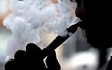 Illustrative: A man smokes an electronic cigarette in Chicago, April 23, 2014. (AP Photo/Nam Y. Huh, File)