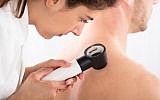 Illustrative image of a doctor using a dermatoscope for a skin examination for melanoma (AndreyPopov, iStock by Getty Images)