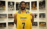 Omri Casspi holding a Maccabi Tel Aviv jersey upon announcing he is returning to the club after a decade in the NBA, August 13, 2019. (Maccabi Tel Aviv official website)