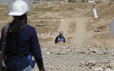 Iraqi mine clearers working for Halo Trust, a non-profit organization specialized in mine removal, scan an agricultural area on August 25, 2019 near Iraq's Baiji, an oil-rich region ravaged by fighting against the Islamic State group (IS) in 2014. (SABAH ARAR / AFP)