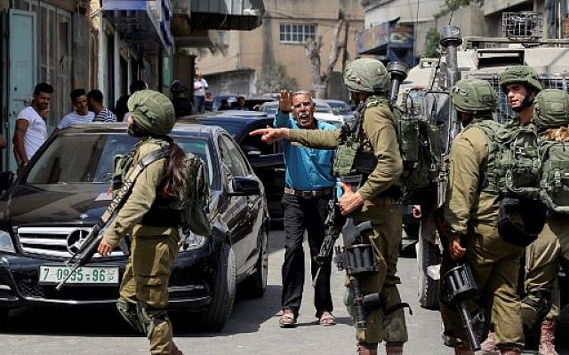 Israeli security forces conduct a search operation following a reported stabbing attack in the West Bank village of Azzun near Qalqilya on September 7, 2019. (Jaafar Ashtiyeh/AFP) Israeli security forces conduct a search operation following a reported stabbing attack in the West Bank village of Azzun near Qalqilya on September 7, 2019. (Jaafar Ashtiyeh/AFP)