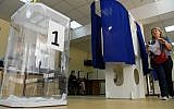 A woman prepares to cast her vote at a polling station during to the Moscow city Duma election in Moscow on September 8, 2019. (Photo by Kirill KUDRYAVTSEV / AFP)