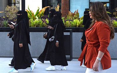 Saudi human resources professional Mashael al-Jaloud, right, walks in Western clothes past women wearing niqabs and abayas, an Islamic dress-code for women, at a commercial area in the Saudi capital Riyadh on September 3, 2019. (Fayez Nureldine/AFP)